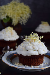 Chocolate capcakes with vanilla cream sprinkled with white chocolate and elderberry flowers....