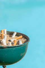 Cigarette butts in the urn. Cigarette disposal urn full of cigarettes with space for text. vertical photo