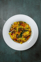 Homemade tortellini in broth in a top view