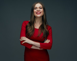 beautiful woman in red dress standing with crossed arms.