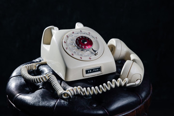 An old white telephone with cord