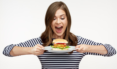 happy woman holding burger on white plate.