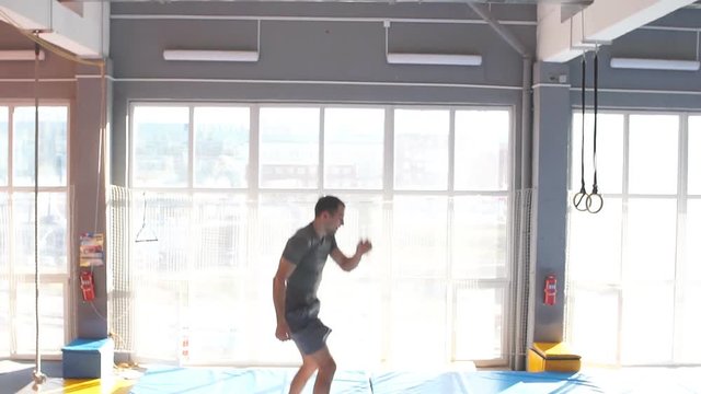 Young ambitious sportsman is going to do a stunt at trampoline. slow motion
