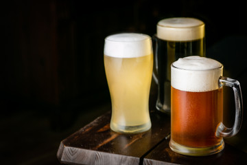 Selection of different types of beer in glasses in pub background, copy space
