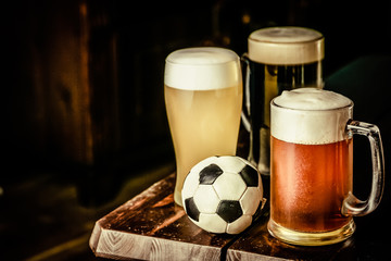Selection of different types of beer in glasses in pub with soccer ball, football championship...