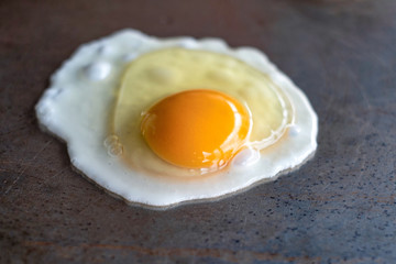 Cooking fried egg on a hot pan for breakfast