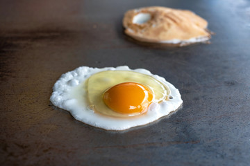 Cooking fried egg on a hot pan for breakfast