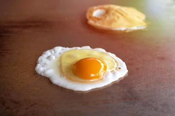 Cooking fried egg on a hot pan for breakfast