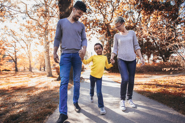Happy young mixed race couple spending time with their daughter having fun