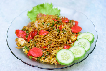 Home made style fried noodles with beef sausage, vegetables, scrambled eggs, meat balls and minced chicken being pulled using chopsticks by hand