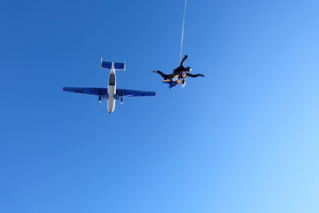 Tandem skydiving. Girl-passenger is having fun in the sky.