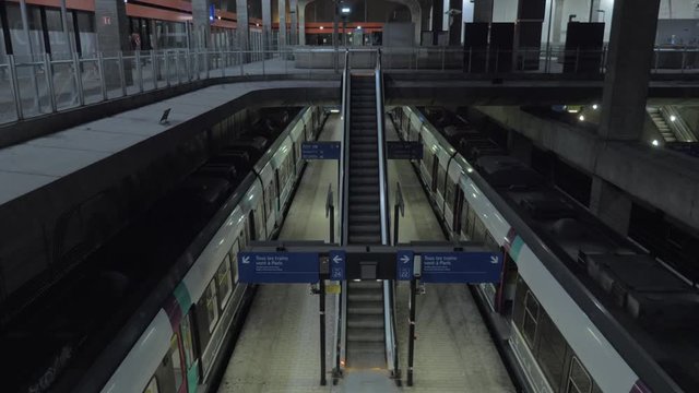 Cinemagraph - High angle shot of subway station with nobody there. Moving empty escalator leading to the platform with arrived trains. Paris, France