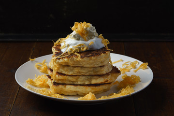 cheese pancakes with sourcream topping on black background