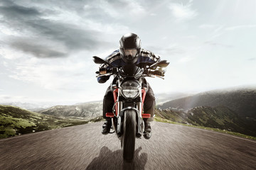 The biker in action or movement on mountain highway, riding around a curve road. The motion toned...