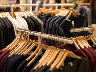 Fototapeta premium Clothing store concept. Lot of clothes on hangers.