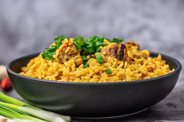 Rice pilaf with meat carrot and onion on grey background. Side view