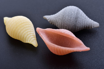 Pasta conchiglie on black background
