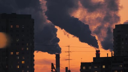 Smoke pollution from smokestacks over residential buildings city skyline silhouette. 4K UHD Timelapse.