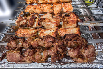 Skewers with pieces of mutton meat lie on the grill