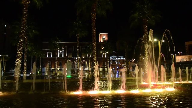 Illuminated and colorful fountain at night. Multi-coloured water jets in fountain pool. City cente Durres, Albania