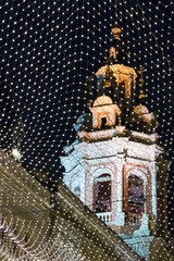 Orthodox church on the background of the night sky, behind the grid with lights