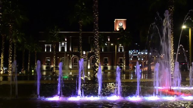 Illuminated and colorful fountain at night. Multi-coloured water jets in fountain pool. City cente Durres, Albania