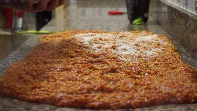 cuoco italiano che condisce il riso col parmigiano