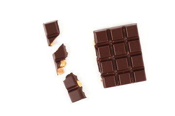 bar of dark chocolate with hazelnuts. Pieces of chocolate with nuts, isolated on white background.