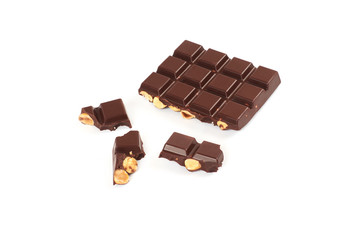 bar of dark chocolate with hazelnuts. Pieces of chocolate with nuts, isolated on white background.