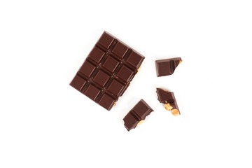 bar of dark chocolate with hazelnuts. Pieces of chocolate with nuts, isolated on white background.