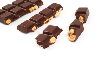 bar of dark chocolate with hazelnuts. Pieces of chocolate with nuts, isolated on white background.