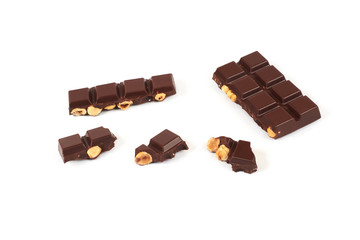 bar of dark chocolate with hazelnuts. Pieces of chocolate with nuts, isolated on white background.