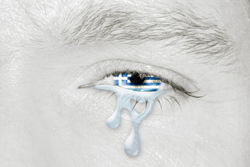 Crying eye with the flag of Greece in iris on black and white face. Concept of sadness for Greek pain about financial crisis, austerity, financial plan and patriotic metaphor.