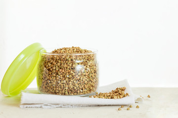 Opened can of green buckwheat on white background with copy space.