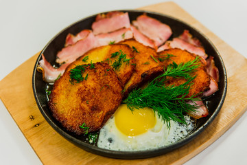 Potato pancakes with fried egg, bacon and dill