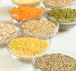 Several glass cups with superfoods on white table.