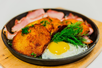 Potato pancakes with fried egg, bacon and dill