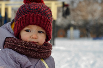 Child at winter. Happy little girl or boy outdoors in red hat