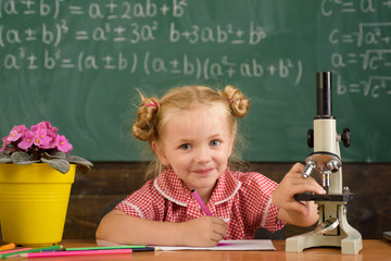 Little girl make scientific experiment with microscope in school laboratory. If at first you dont succeed try another experiment