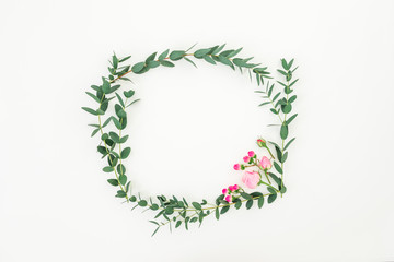 Floral wreath frame of pink roses flowers and eucalyptus branches on white background. Flat lay, top view