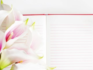 open notebook and beautiful calla artificial pink flowers bouquet