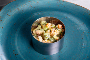 Russian salad on a green plate