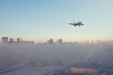 Fototapeta na wymiar Landing airplane above the Astana city with skyscrapers and old town. Astana town in the plane window