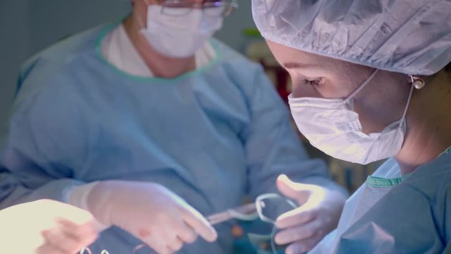 Medical Team Performing Surgical Operation in Bright Modern Operating Room.