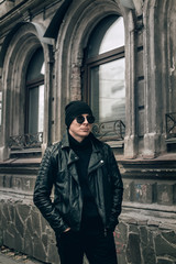 Fototapeta na wymiar stylish guy in a black leather jacket and sunglasses