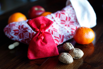 Nikolaustag, Adventszeit mit Strumpf, Adventskalender, Geschenk, Äpfeln, Nüssen, Orangen, weihnachtlicher Dekoration.