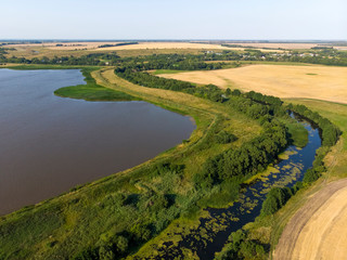Natural landscape of central Russia with field, river and pond in August