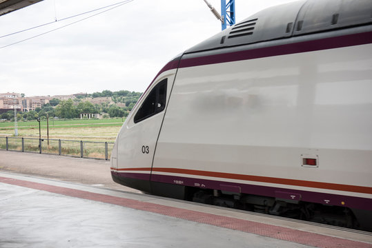 A local metro transportation is seen on this picture. Metro railway is one of the most popular forms of transportation in Spain. The railway tracks are also seen on the background.