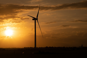 Fototapeta na wymiar Wind turbine farm or windmill on golden sunset sky in summer day. High-quality stock photo image of wind turbine or windmill for clean energy concept. Energy Production with clean and Renewable Energy