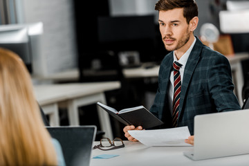 partial view of businessman and businesswoman working on new business project together at workplace in office